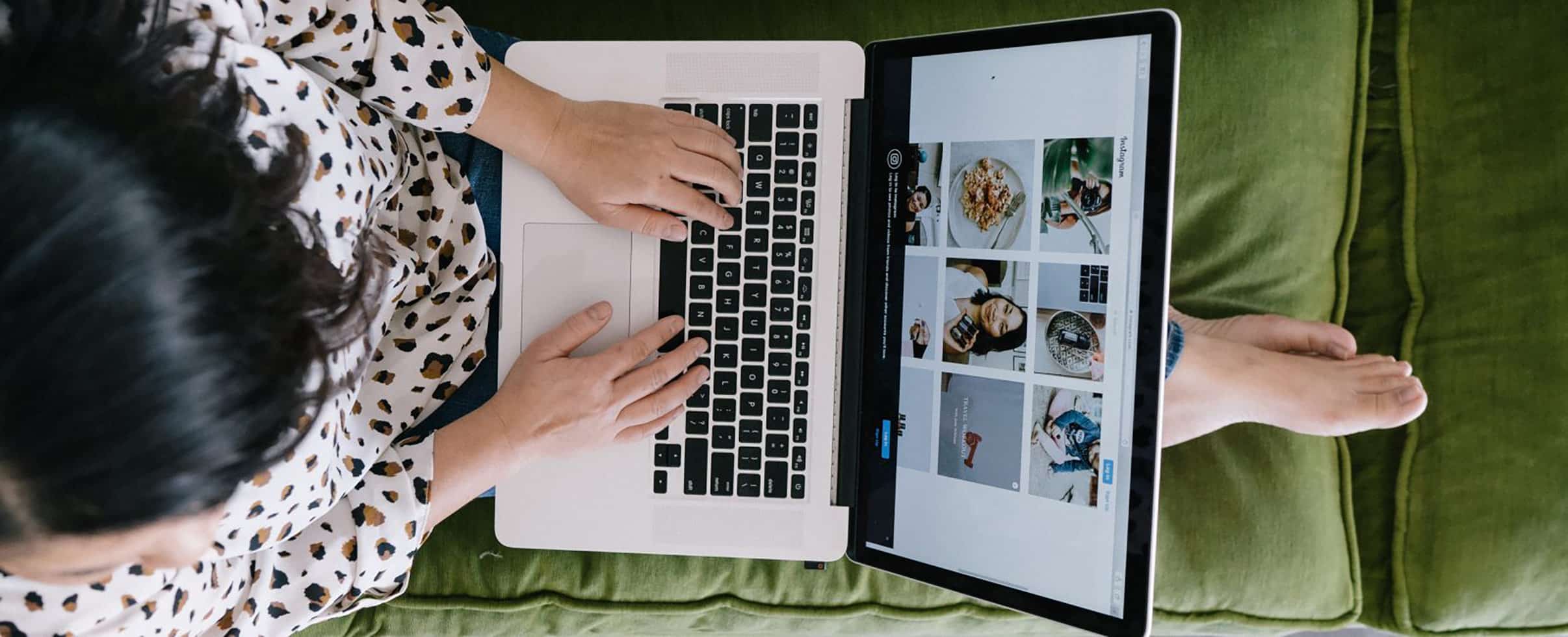 Woman working at her laptop on a green sofa