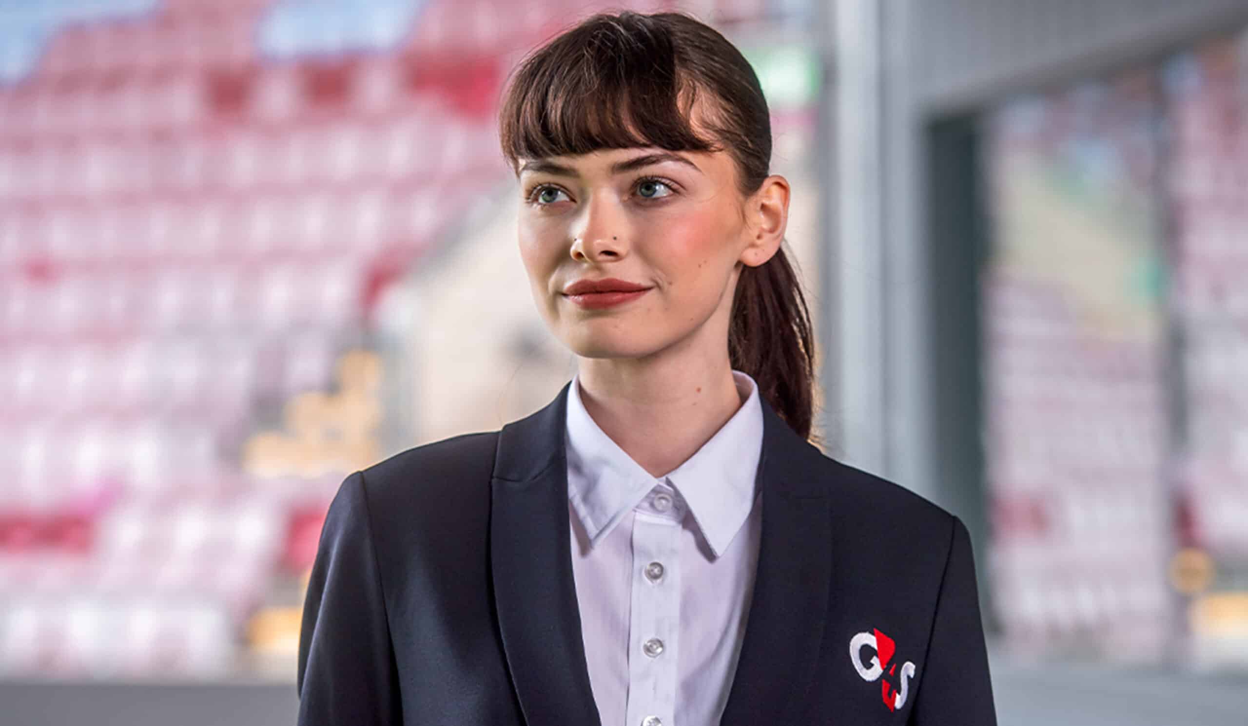 A woman who works in security wearing a blue blazer with the G4S logo
