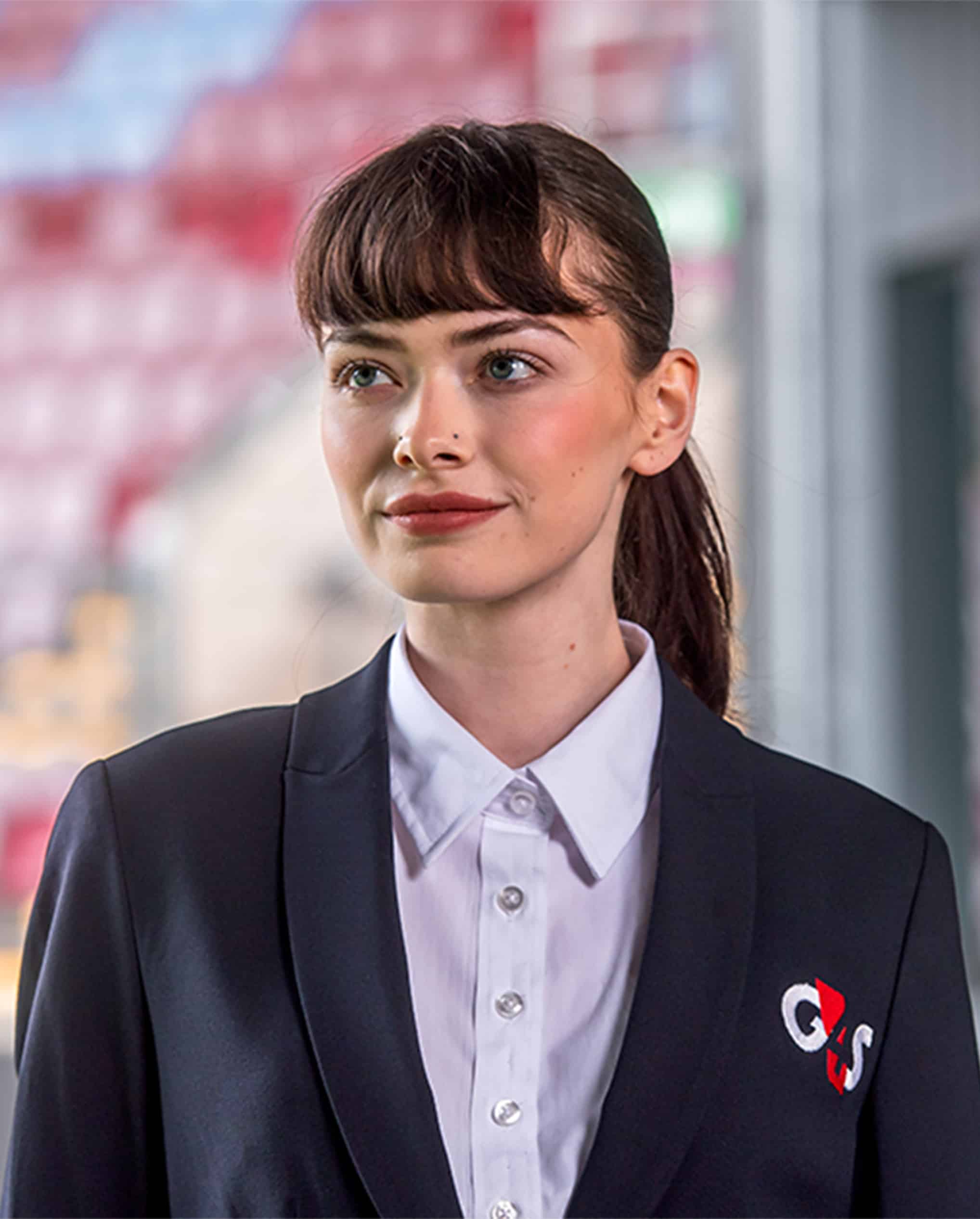 A woman who works in security wearing a blue blazer with the G4S logo